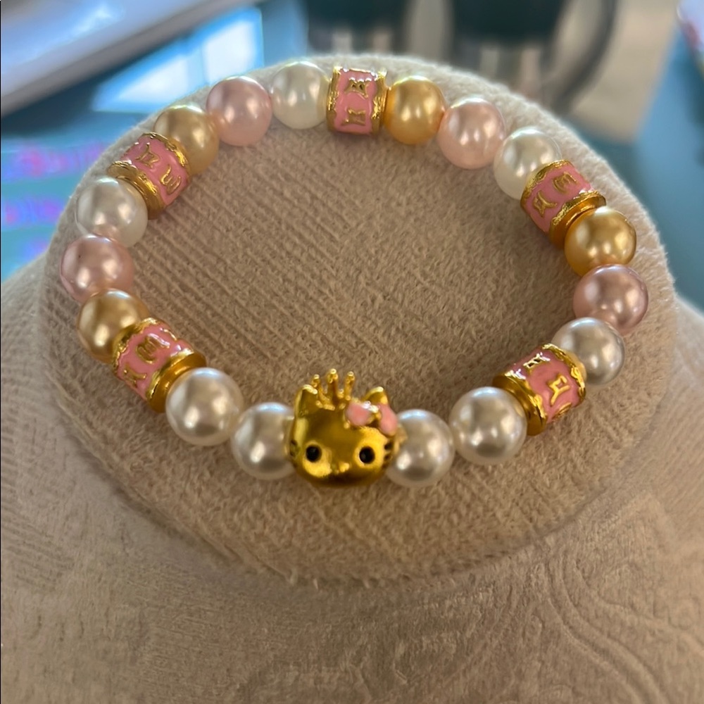 Hello Kitty Gold tone, yellow and pink faux pearl bracelet.